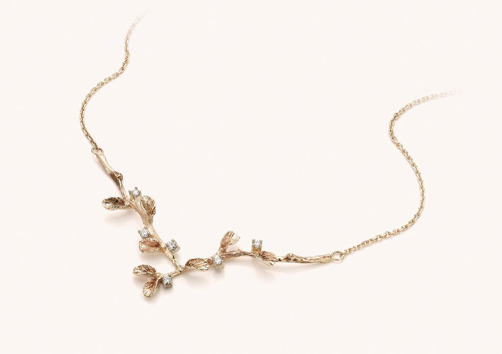 witgouden  halsketting met diamant en  takjes/blaadjes motief
